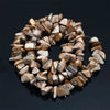 A collection of natural, tumbled agate stone beads in various shades of beige and brown arranged in a circular pattern.