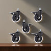 A set of black universal furniture caster wheels mounted on a wall, shown in various angles.