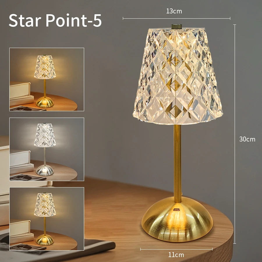 A gold-toned, faceted crystal lampshade on a slender stand, illuminated by a warm light.