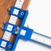A blue adjustable cabinet hardware installation jig with a ruler used for measuring and alignment.