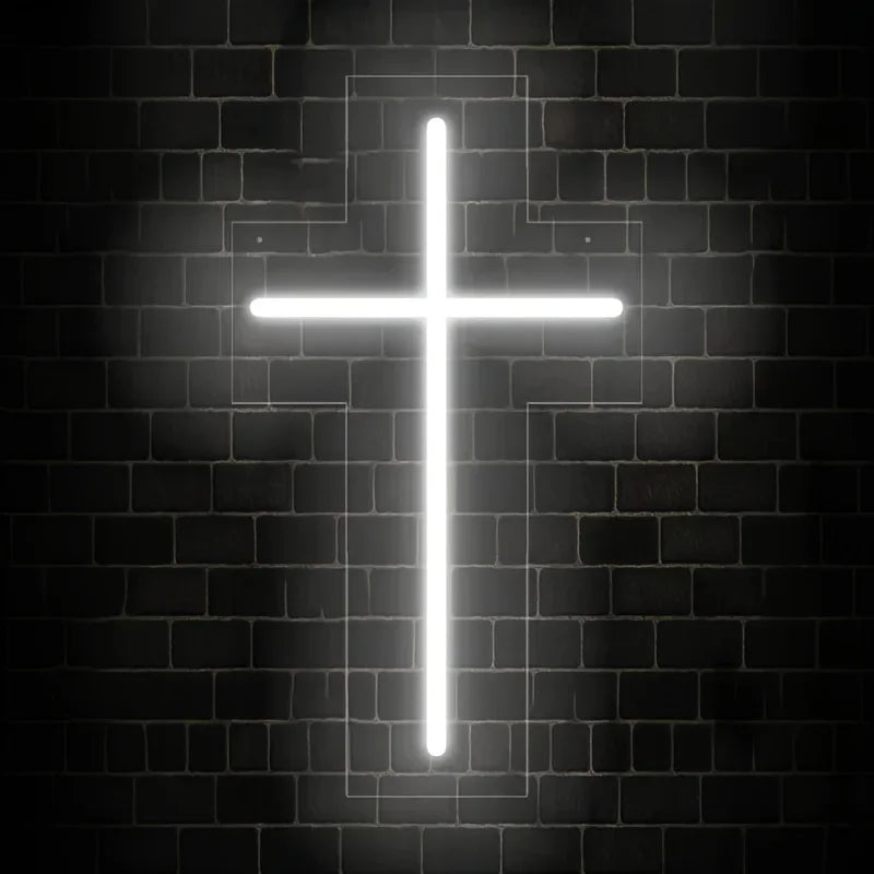 Una cruz blanca brillante iluminada en una pared de ladrillo oscuro.