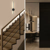 Interior moderno con escalera y apliques de pared con luminarias giratorias.
