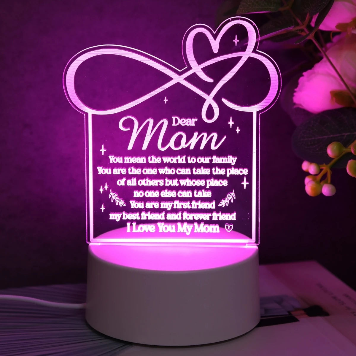 A glowing silhouette of a heart design on a clear acrylic night light featuring a message for Mom