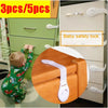 A set of silicone baby safety locks for doors and drawers shown next to a wooden block.