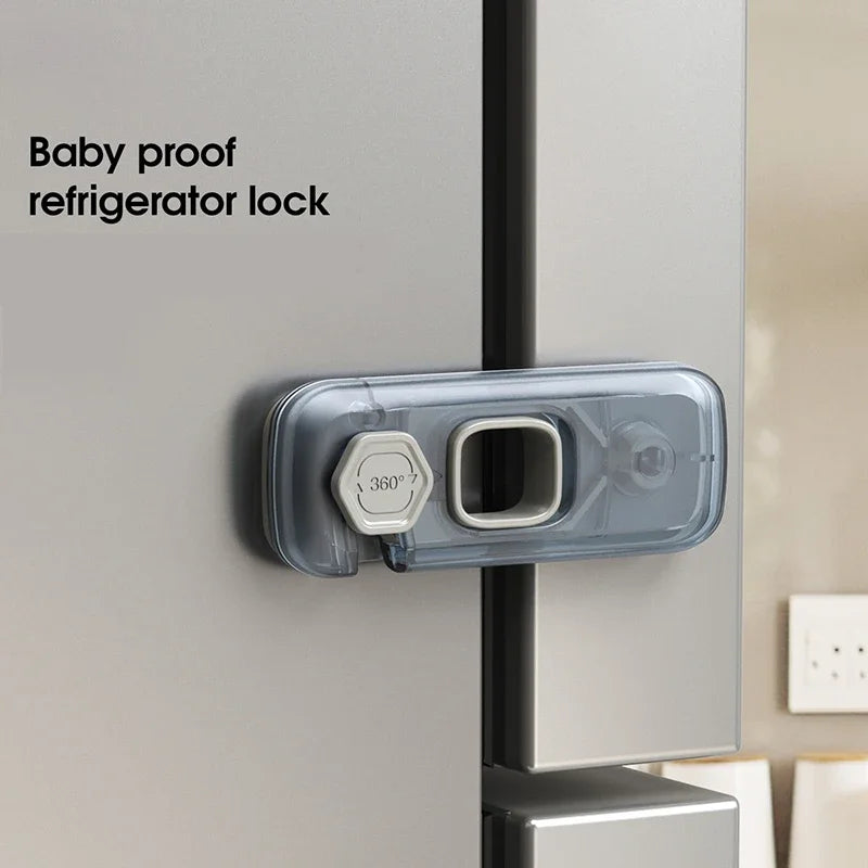 A baby proof refrigerator lock, a clear plastic latch with a 360-degree turn mechanism, attached to a silver refrigerator doo