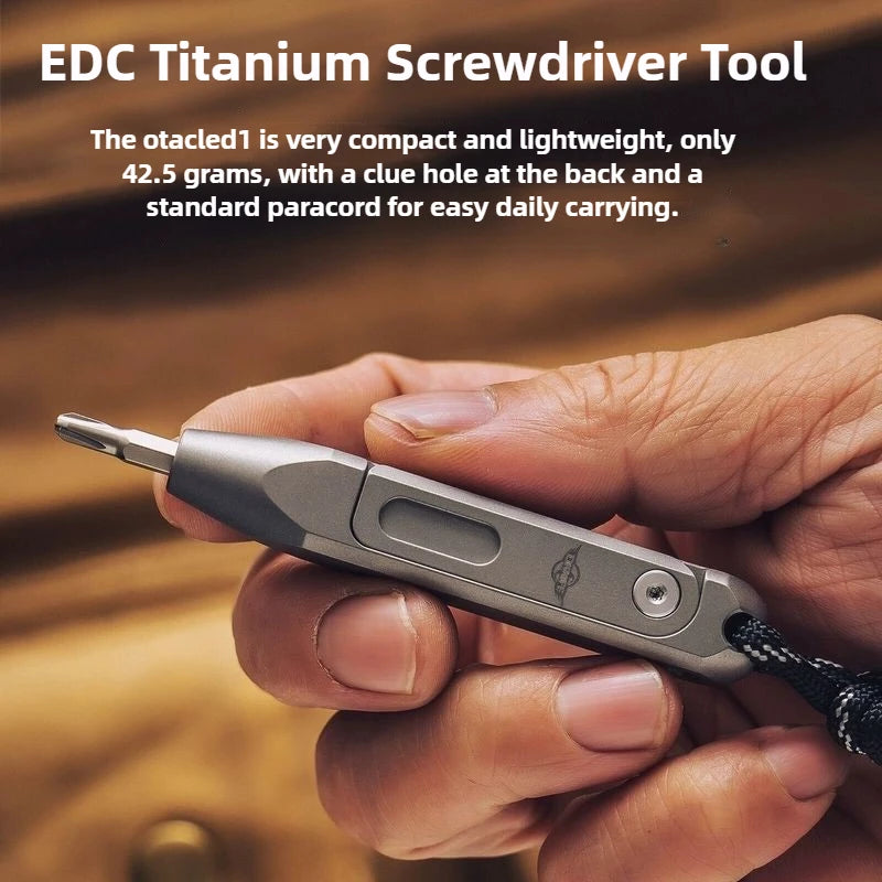 A hand holds an EDC Titanium screwdriver tool with a black paracord lanyard.