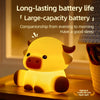 A yellow silicone night light shaped like a Highland cattle, illuminating a wooden surface.