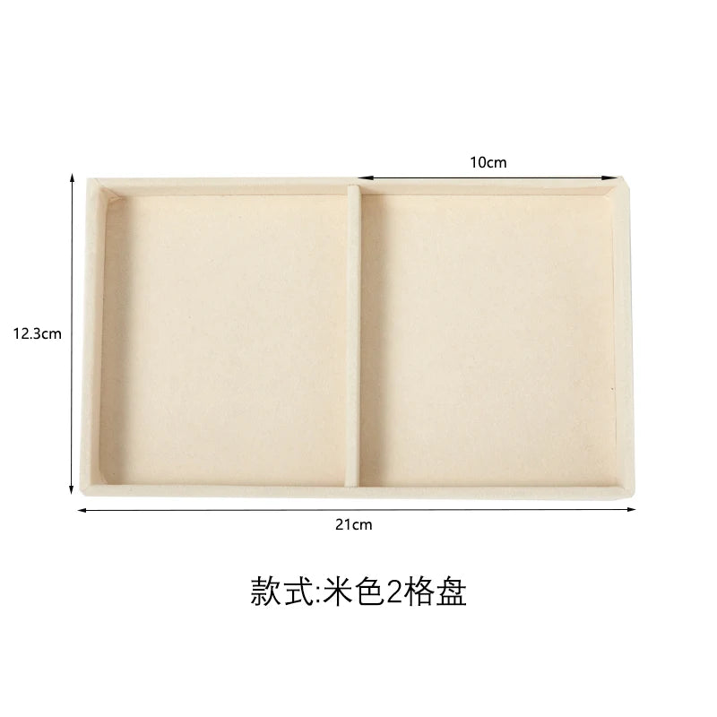 A light beige jewelry storage tray with two compartments, measuring 10cm by 12.3cm.