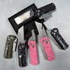 A black case holds a folding utility knife with a stainless steel blade and pink patterned handle.