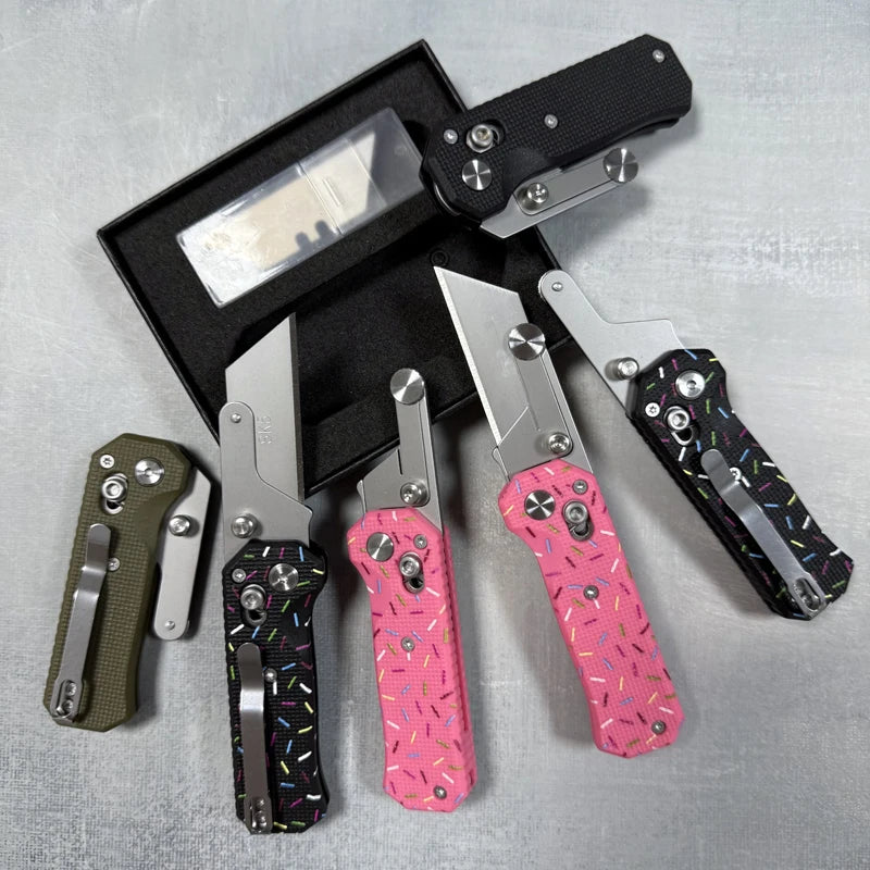 A black case holds a folding utility knife with a stainless steel blade and pink patterned handle.