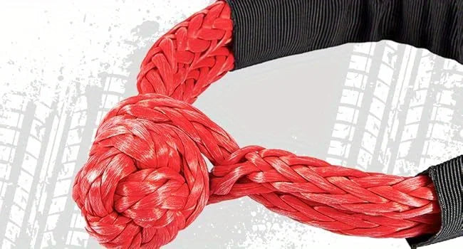A close-up of a thick red synthetic winch rope coiled and wrapped around a black sleeve.