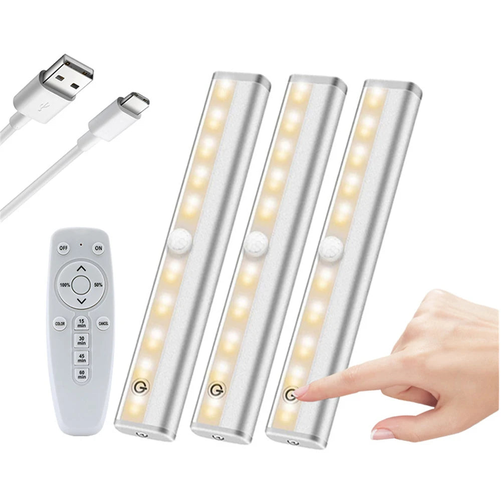 Three long LED light bars with remote controls and a power adapter are shown next to a hand.