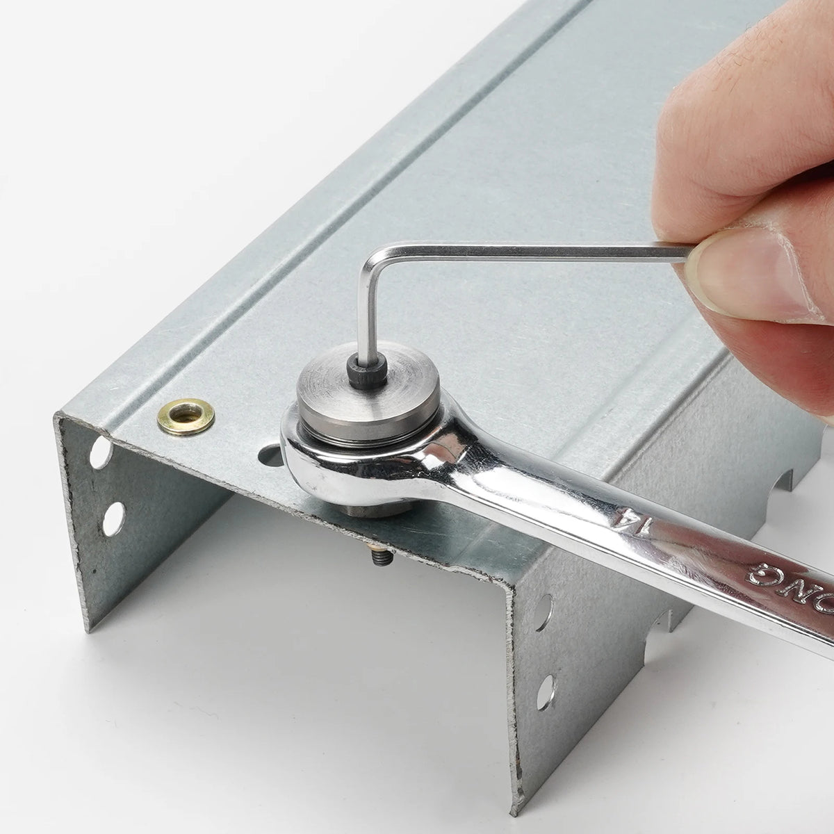 A hand is holding a precision hand rivet nut gun, which is inserted into a metal panel.