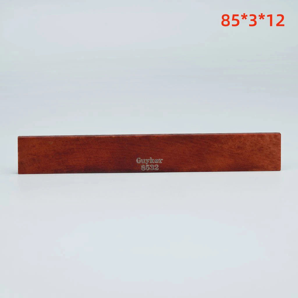 A rectangular piece of brown acoustic guitar bone bridge saddles labeled Guybox 5932