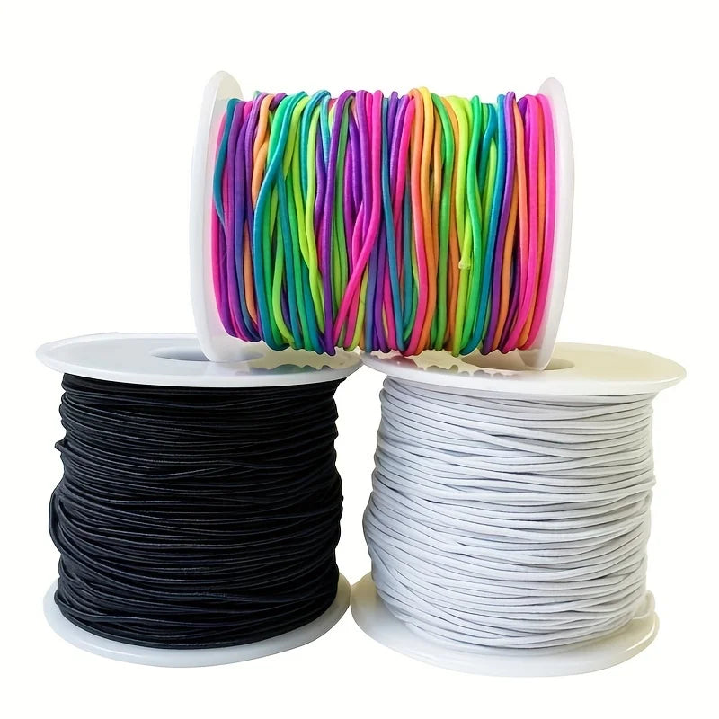 Spools of colorful rainbow elastic beading cord in various colors and a spool of white cord.
