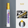 A gold and white solid paint marker pen with a tip, shown against a gray background.