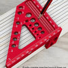 Règle triangulaire en aluminium rouge de précision graduée de 3mm à 77mm, posée sur une surface en bois.