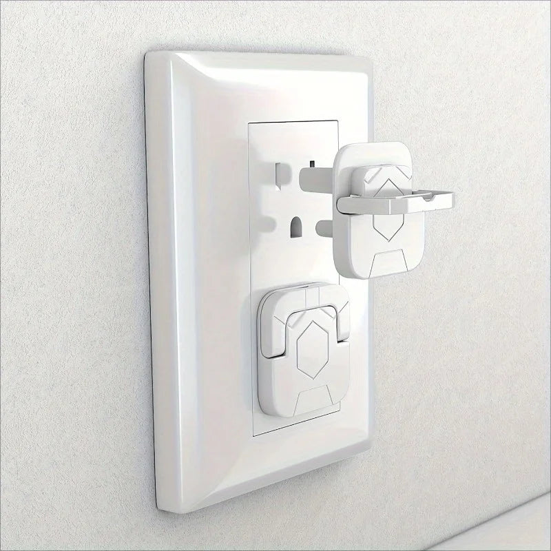 A white plastic outlet cover for baby proofing mounted on a wall.