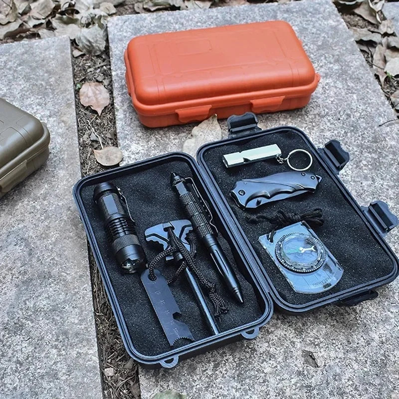 Schwarze Aufbewahrungsbox mit Werkzeugen und einem kleinen orangefarbenen Plastikbehälter auf einer Steinoberfläche.