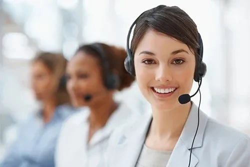 A smiling woman wearing a headset and white coat is shown in a professional setting.