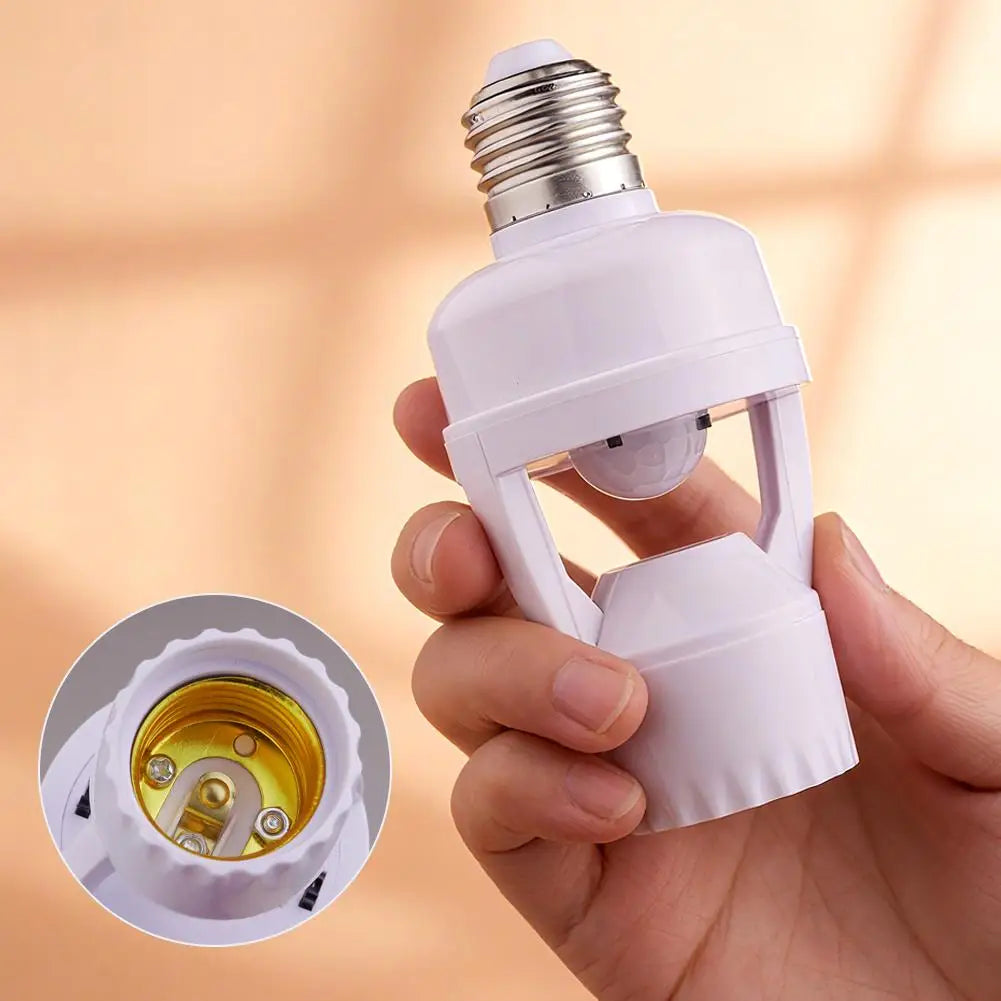 A hand holds a white light bulb adapter with a screw-in base and a translucent bulb, showing the internal components.