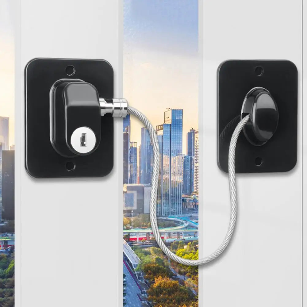 A black universal door and window safety lock installed on a white panel, featuring a cylindrical latch and a braided cord.