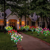 Colorful solar LED azalea flowers lining a brick pathway in a garden setting.