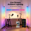 Two vertical RGB LED floor lamps are displayed next to a desk with various electronic devices.