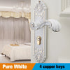 A white European style door lock with decorative scrollwork and four copper keys mounted on a wall.