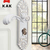 A decorative European style gold door lock with keys mounted on a white wall.
