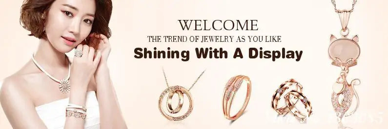 Close-up of various gold and rose gold rings displayed next to a woman wearing a necklace.