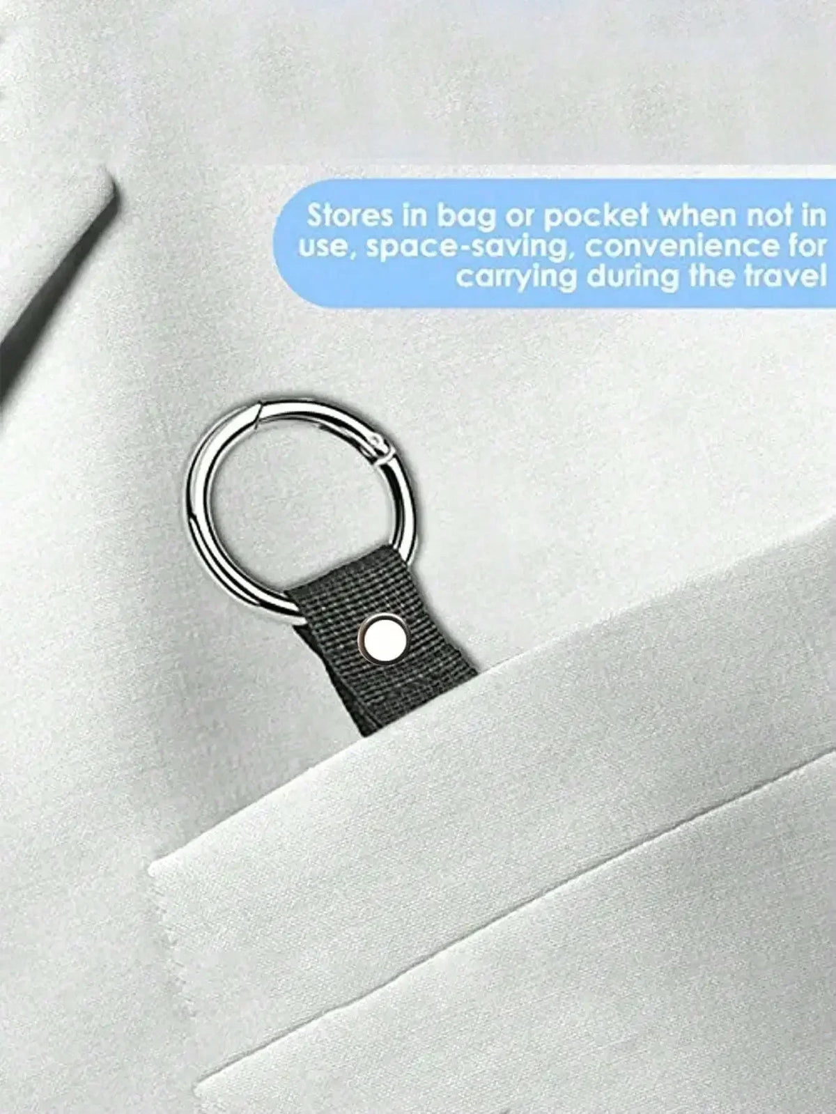 Ein Set aus schwarzem Gepäckriemen und Rucksackclip an einem hellgrauen Sakko-Revers.