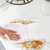 A hand is applying marble self-adhesive waterproof contact paper onto a white table surface.