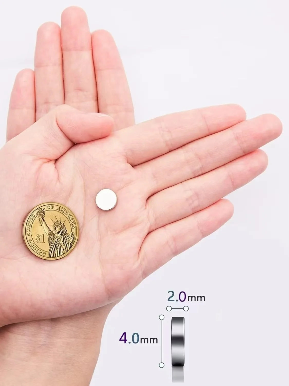 A hand holds a round gold coin magnetic sticker and a silver bar for scale.