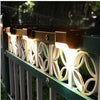 A row of solar LED outdoor deck lights with white decorative panels mounted on a green railing.