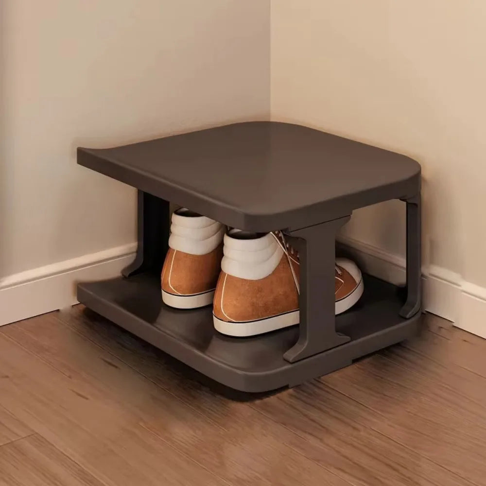 A gray stackable vertical shoe rack organizer holding pairs of brown and tan boots.