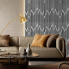 A modern living room featuring a beige sofa, pillows, and a gold floor lamp against a dark gray vertical wood grating wall.
