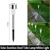 A solar stainless steel tube lamp with a white light mounted on a black base, shown in an outdoor pathway context.