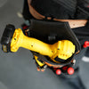 A yellow heavy-duty cordless tool holster holding a drill bit in a black padded pouch.