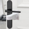 A black and white universal adhesive door latch mechanism is mounted on a white door frame.