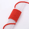 Orange braided polyester craft cord wrapped around a clear plastic tube