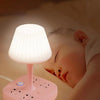 A pink conversion desk lamp with light source illuminating a baby's face while sleeping.