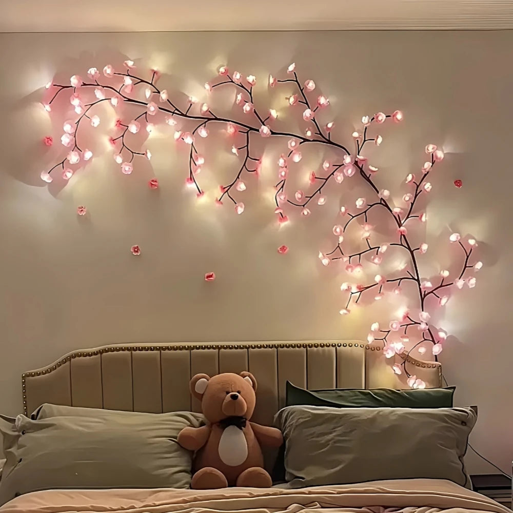 LED cherry blossom tree lights illuminating a bedroom wall above a bed.