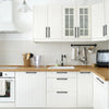 A modern kitchen featuring white cabinetry with brushed nickel and gold cabinet handles.