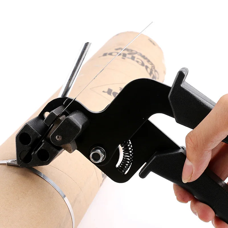 A hand is operating a black stainless steel cable tie cutting tool on a roll of tape.
