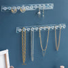 Wandmontierter Acryl-Anhängerorganizer mit verschiedenen goldenen und silbernen Halsketten.