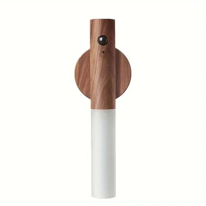 Luz nocturna LED con sensor de movimiento de madera y base cilíndrica blanca.