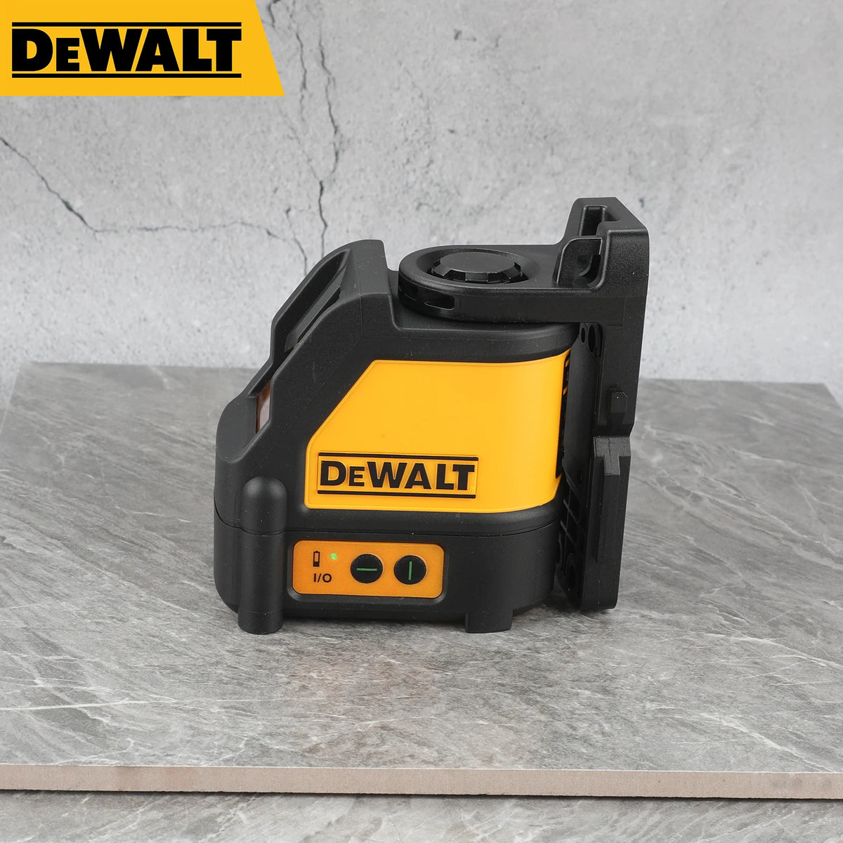 A black and yellow DEWALT laser level tool resting on a gray stone surface.