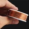A hand holds a spool of high-conductivity bare copper wire with a white plastic casing.