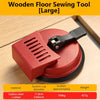 A large red wooden floor sewing tool with a suction cup and a handle is shown on a light wood surface.